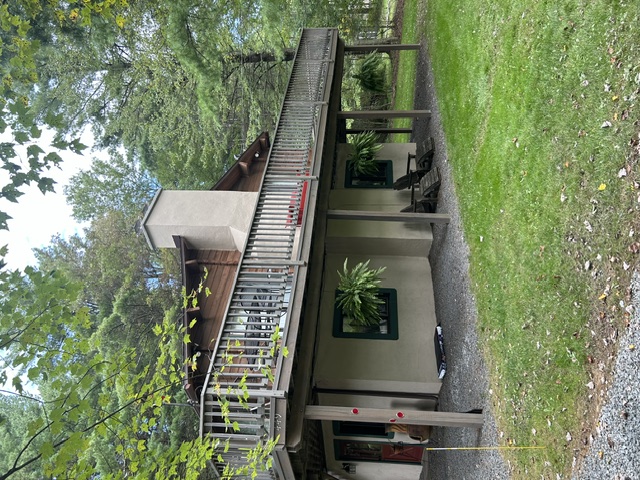 Stucco chimney on wood-sided home with elevated deck