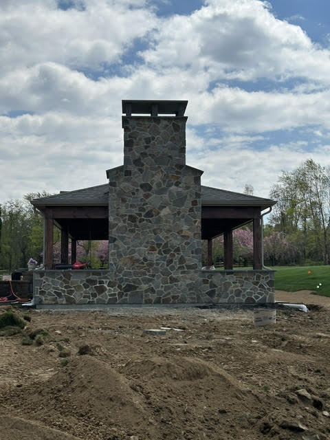 Freestanding stone chimney and pavilion under construction