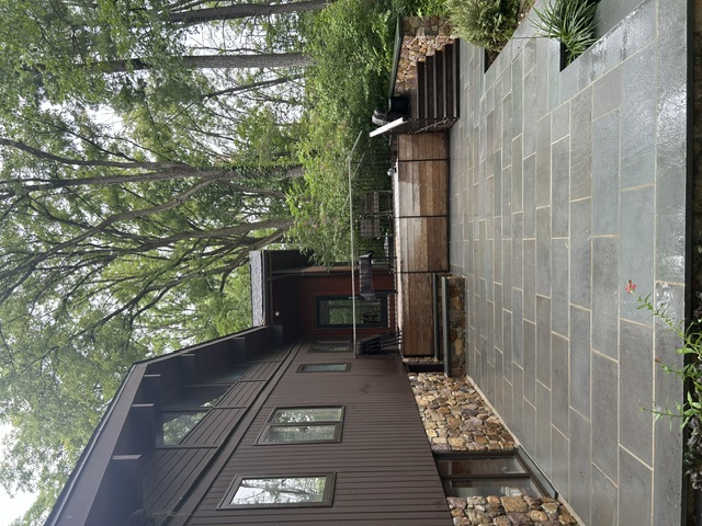 Bluestone patio and stone foundation on wooded home