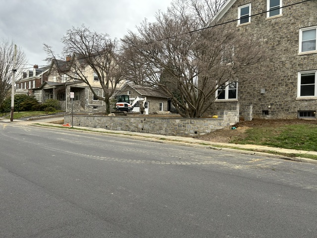 Long natural stone retaining wall along residential street