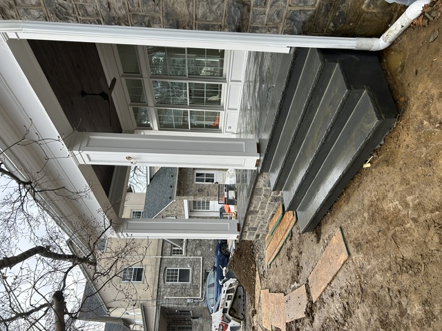 Bluestone porch steps with white columns and stone facade