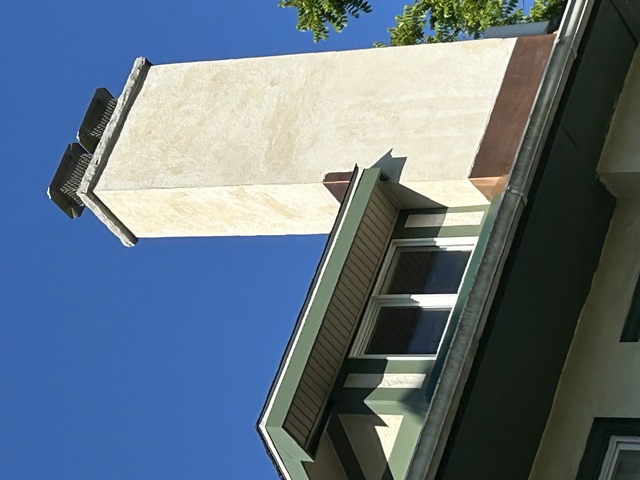 Stucco chimney with clay flue caps and copper flashing