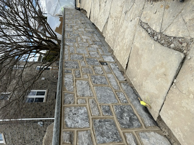 Close-up of hand-cut stone retaining wall with beige mortar joints