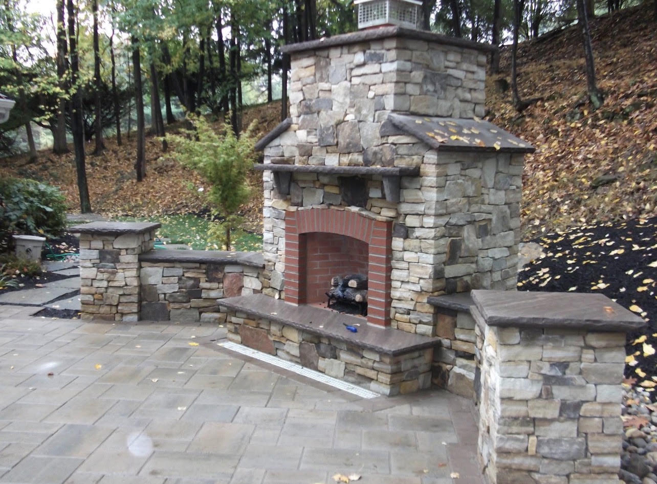 Large outdoor stone fireplace with brick firebox on a paver patio in the Lehigh Valley, PA
