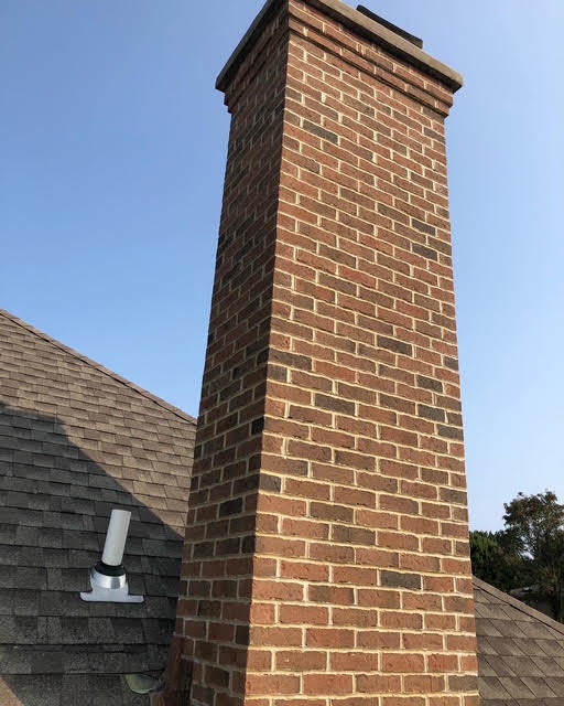 Restored brick chimney with corbeled cap