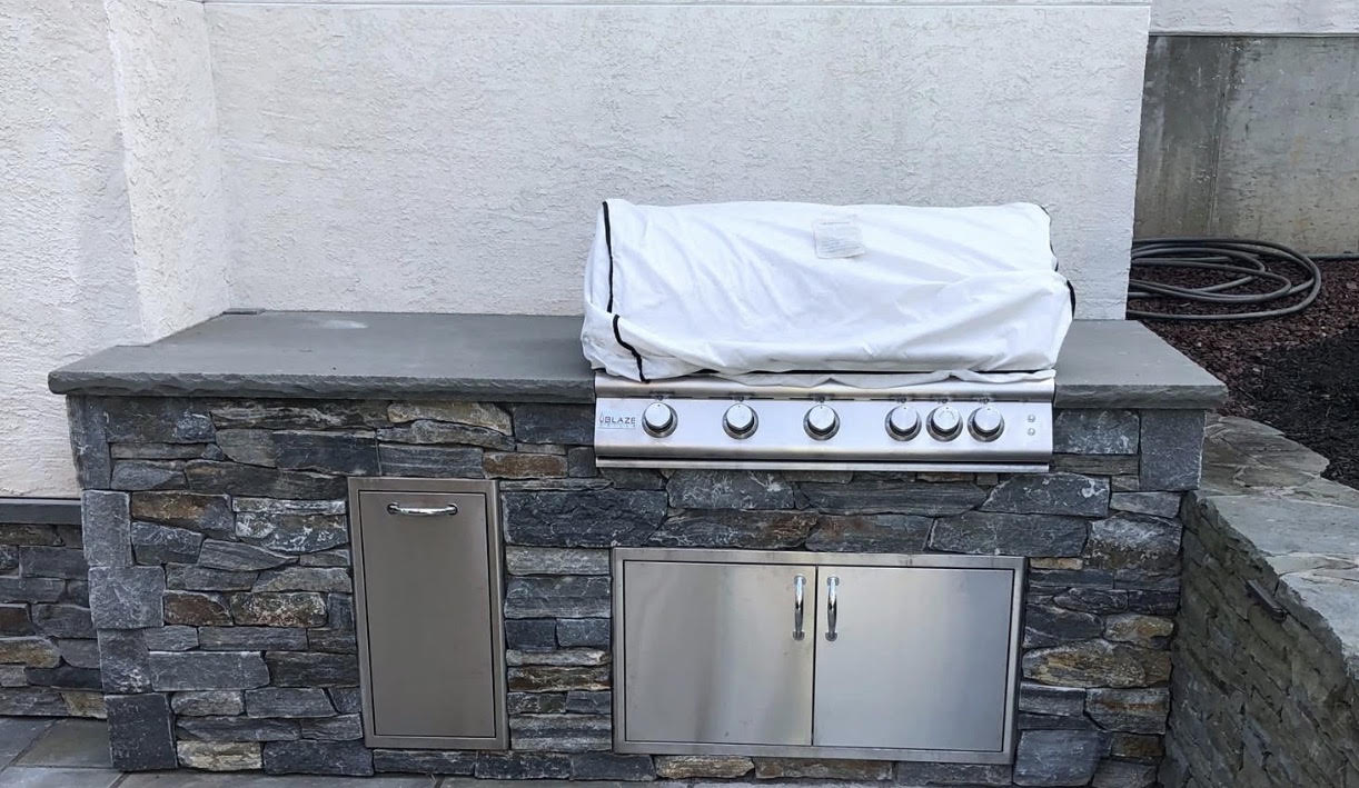 Stacked stone outdoor kitchen with built-in Blaze gas grill and bluestone countertop in the Lehigh Valley, PA